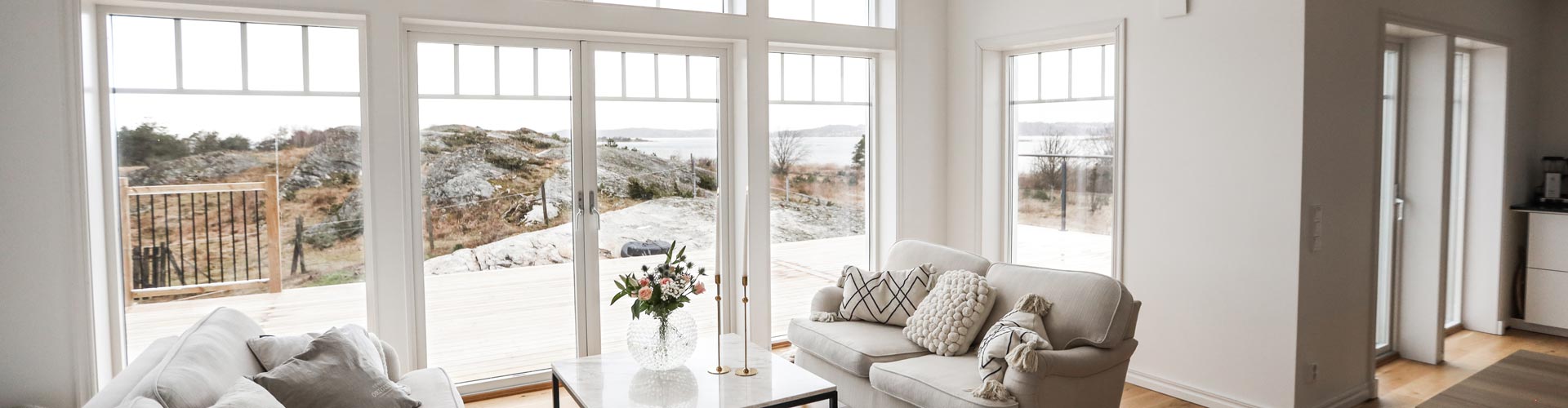 Lantligt New Englandhus med klipporna och havet inpå knuten