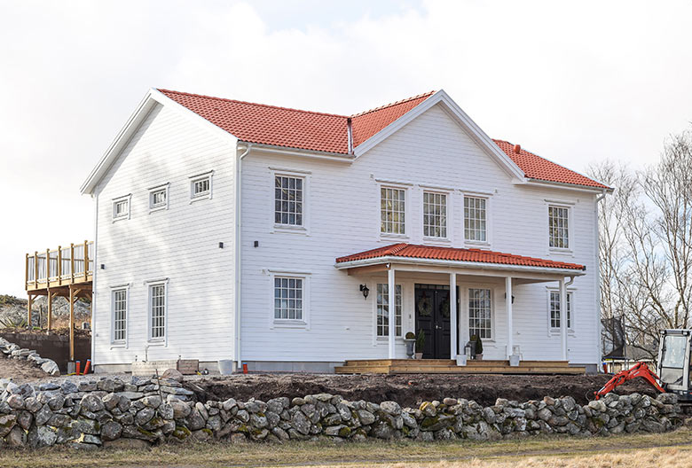 New Englandhus i vitt med rött tegel