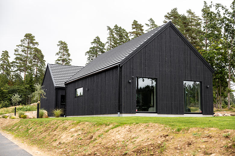 Stora fönster på ett svart hus