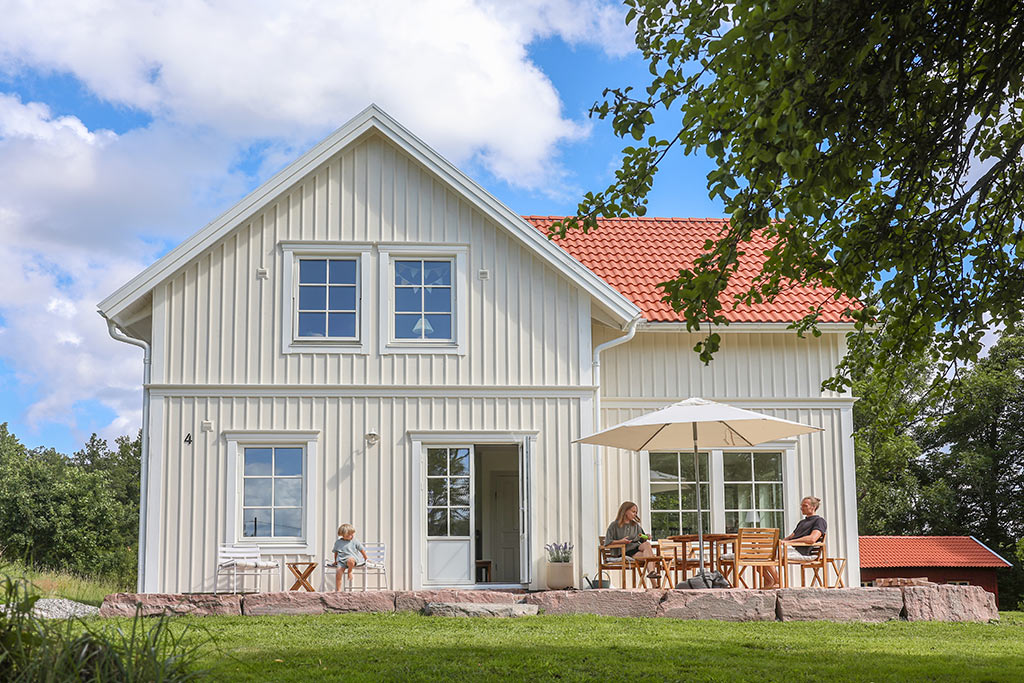 Husets utsida med stengrund runt uteplatsen