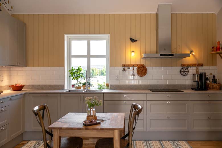 Lantligt kök med vitt kakel och gul panel