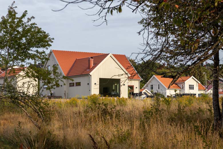 Hus i vinkel med högt gräs framför