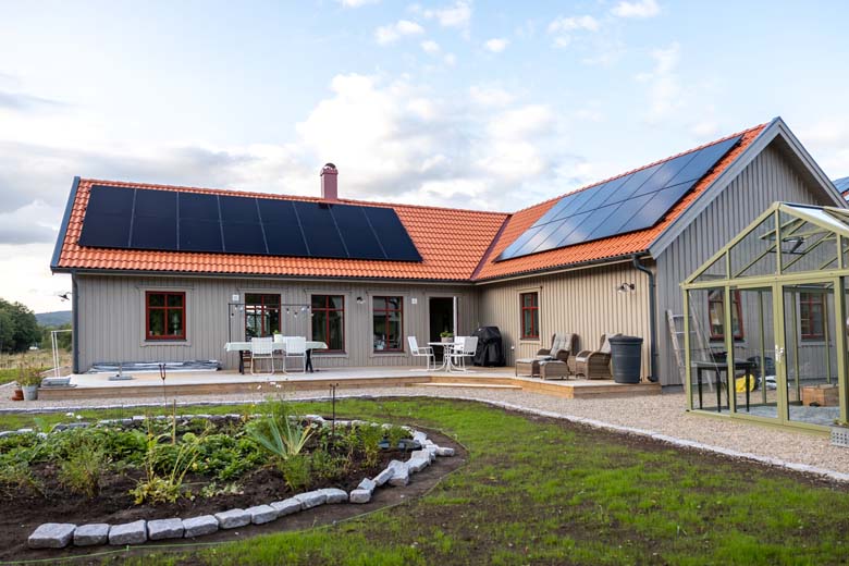 Baksidan av ett hus med solcellspaneler på taket