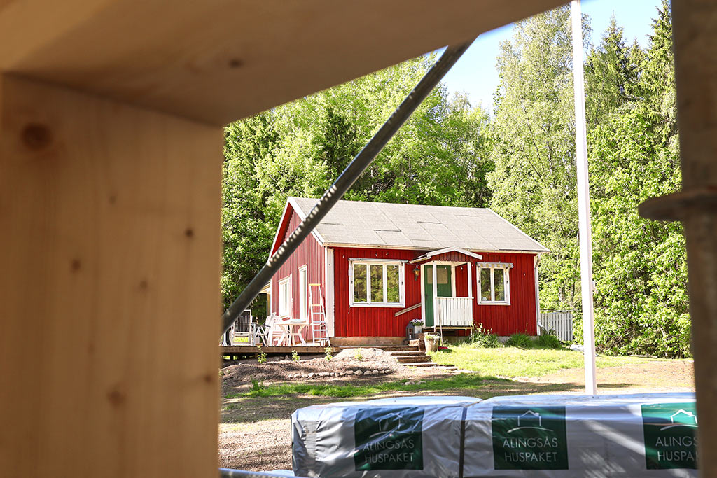 Röd stuga på tomten
