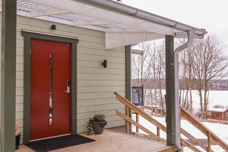 Paret valde en röd ytterdörr som kontrasterar fint mot fasadens gröna toner.