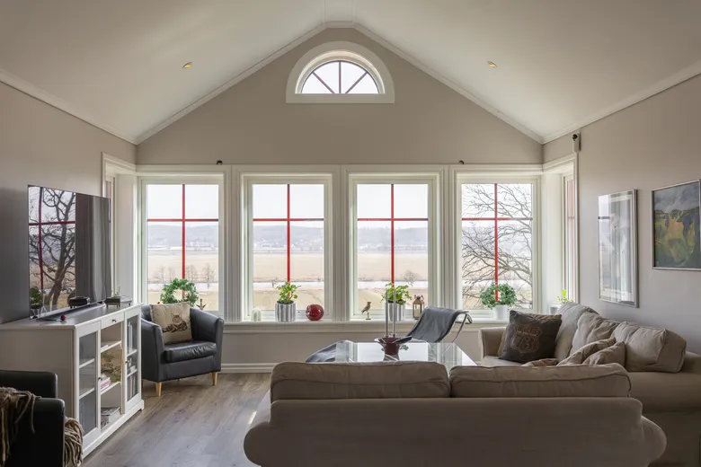 Vardagsrum med stora fönster mot öppet landskap