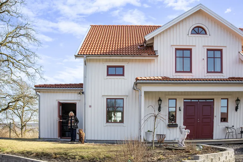 Vitt hus med terrakotta-tak och röd därr