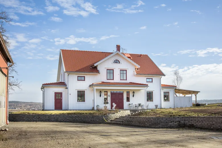 Fronten på ett vitt hus med terrakotta-tak