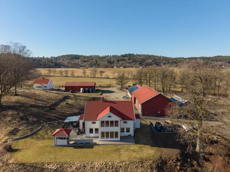 Vitt hus med terrakotta-tak i öppet landskap